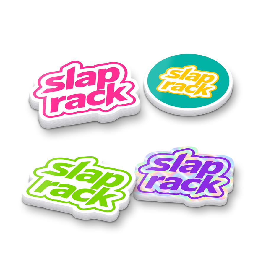 Pile of assorted SlapRack sticker stacks: die-cut logos, a circle and a holographic sticker, white background